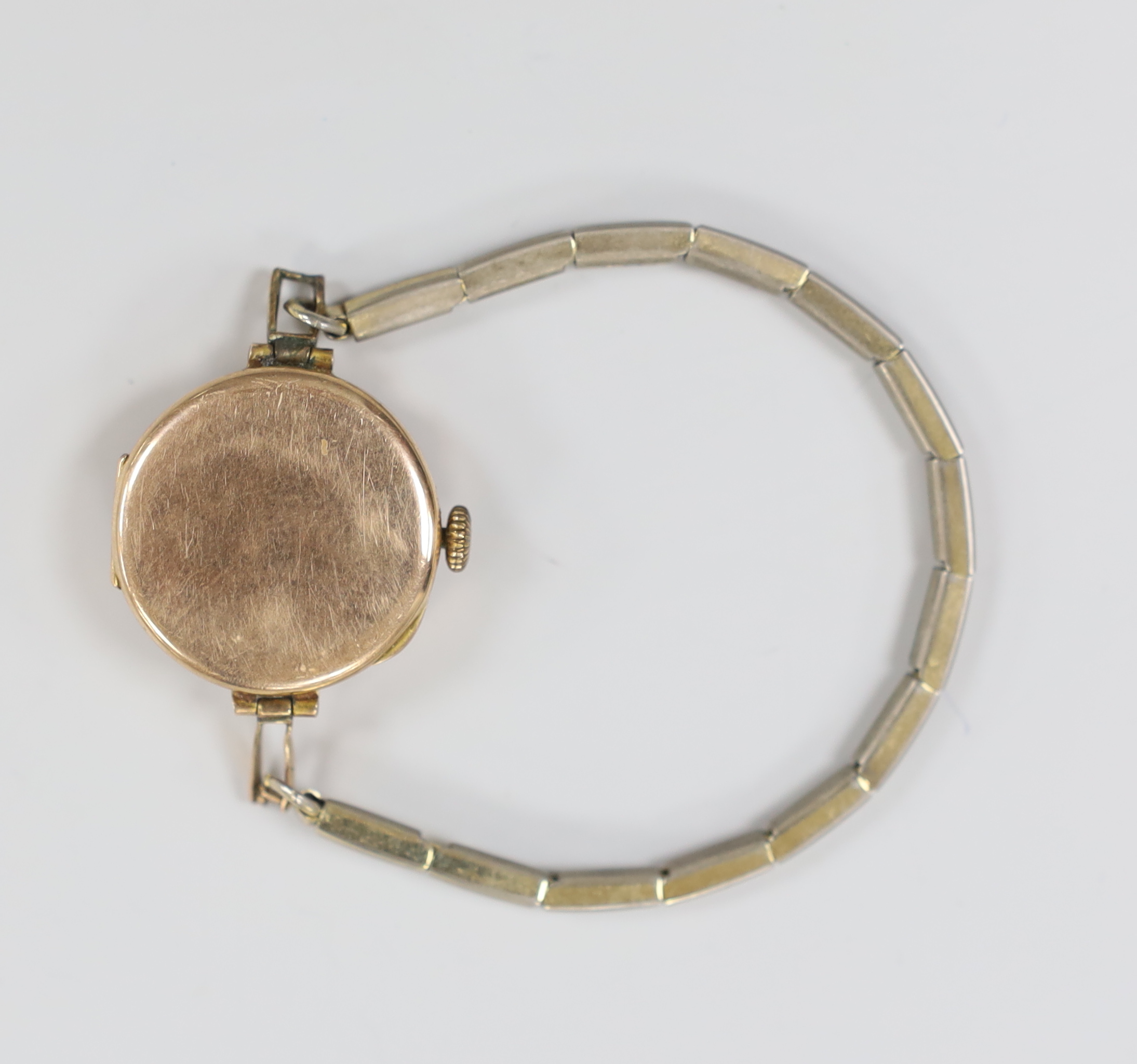 An early 20th century 9ct gold manual wind wrist watch, on a gilt metal flexible strap.